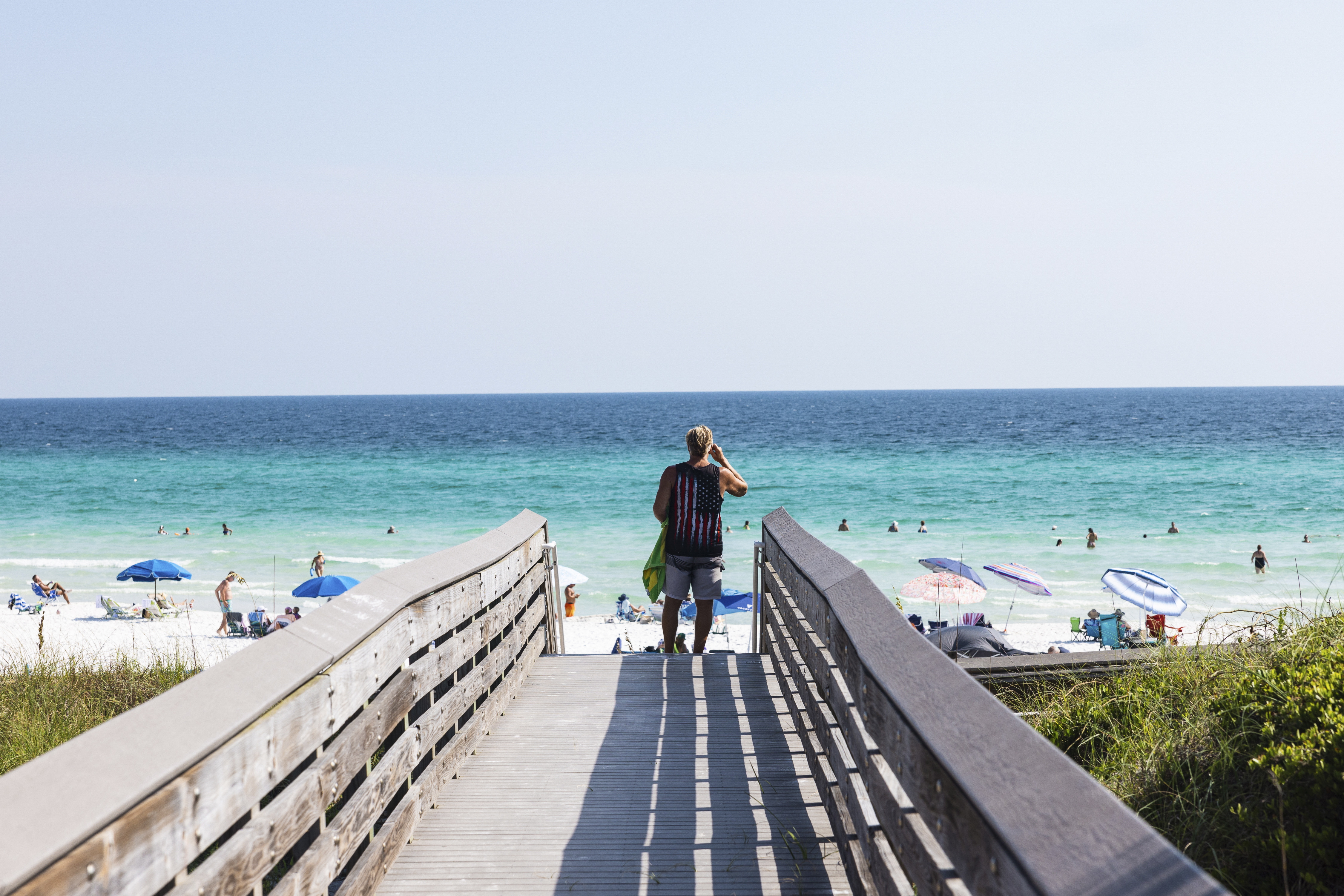 A beachgoer uses the boardwalk at Ed Walline Regional Beach Access off Scenic Highway 30A in Santa Rosa Beach, Fla. This stretch of the Gulf Coast has become "ground zero" in a battle between private property rights and public beach access.